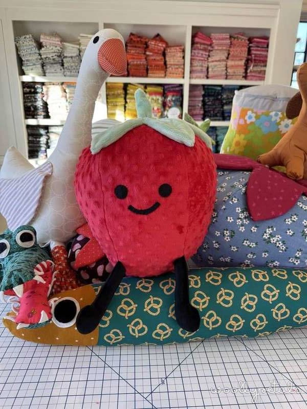 Woollypetals Strawberry Friends pillow with embroidered face and green leaves