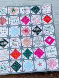 Woollypetals Sparked Quilt with diamond and square blocks in holiday fabrics