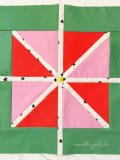 Woollypetals StarFlake Quilt Block in red, pink, and green fabrics