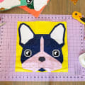 Woollypetals Beatrice Bulldog FPP quilt block with navy, pink, and white fabrics on yellow background