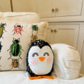 Woollypetals Penguin Pillow with beetle pattern pillow on cream bedding