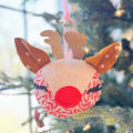 Woollypetals Reindeer Ornament with red nose and glitter antlers on evergreen branch