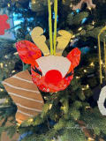 Woollypetals Reindeer Ornament with red patterned fabric, white face, and gold antlers hanging on tree