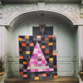 Woollypetals Something Wicked Quilt with witch hat design displayed on doorway