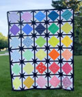 Woollypetals Sparked Quilt with colorful diamond blocks and black star sashing