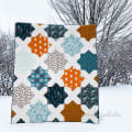 Woollypetals Floored quilt in orange, blue, and cream with diamond-shaped blocks