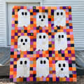 Woollypetals Ghost Party quilt with colorful patchwork and white ghost appliqués