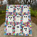 Woollypetals Ghost Party quilt with colorful patchwork and white ghost appliqués