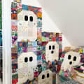 Woollypetals Ghost Party Quilt with colorful patchwork fabric borders and cream ghost blocks