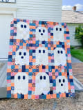 Woollypetals Ghost Party quilt hung on clothesline with colorful patchwork border