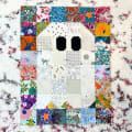 Woollypetals Ghost Party quilt layout with colorful fabric squares and white ghost block center