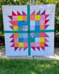 Woollypetals Wash Your Paws quilt with colorful star blocks and teal sashing