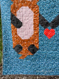 Woollypetals Don't Let Go Quilt with cow face design in blue, brown, and pink