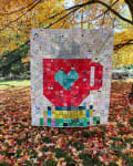 Woollypetals Book Date Patchwork Quilt with heart design displayed outdoors