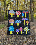 Woollypetals Capped quilt with colorful checkered mushroom blocks on black background