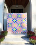 Woollypetals New Star Quilt displayed on front entrance with pink, blue, and yellow fabrics
