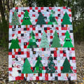 Woollypetals Enchanted Forest quilt with green trees and patchwork squares