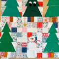 Woollypetals Enchanted Forest quilt with green trees, snowmen, and festive fabric patchwork