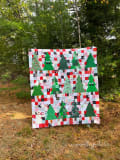 Woollypetals Enchanted Forest Quilt with green triangle trees and patchwork background
