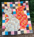 Woollypetals Squirrel quilt with colorful patchwork blocks and appliqué design