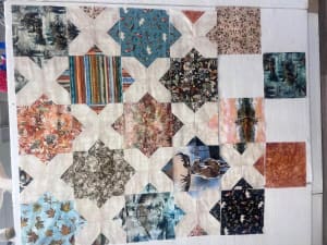 Woollypetals Floored quilt layout with patchwork star blocks in varied fabrics