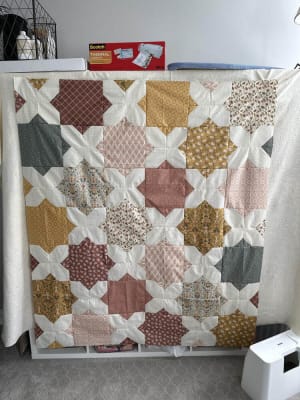Woollypetals Floored quilt with star blocks in cream, gold, burgundy, and gray fabrics