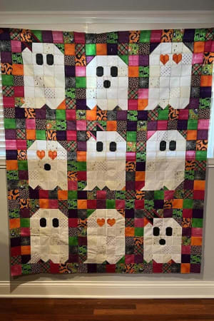 Woollypetals Ghost Party quilt with nine white ghost blocks on colorful patchwork background