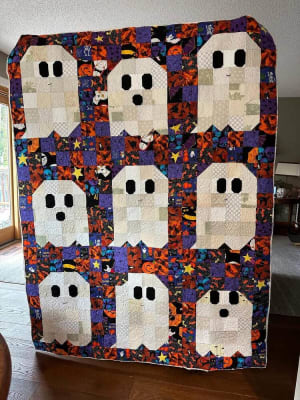 Woollypetals Ghost Party quilt with nine cream ghost blocks on Halloween fabric
