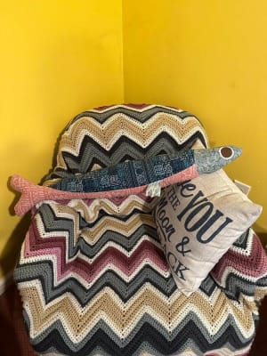 Woollypetals Sardine Pillow in chevron fabrics stacked with fish-shaped plushies