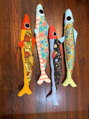 Woollypetals Sardine Pillow in four colorful fabric combinations on wood