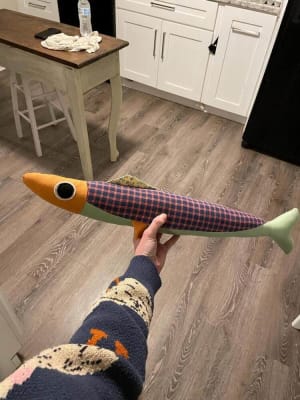 Woollypetals Sardine Pillow in plaid and solid fabrics being held up