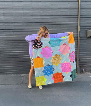 Woollypetals Floored10 quilt with colorful star blocks on bright green background