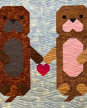Woollypetals Don't Let Go quilt featuring two figures with a red heart between them