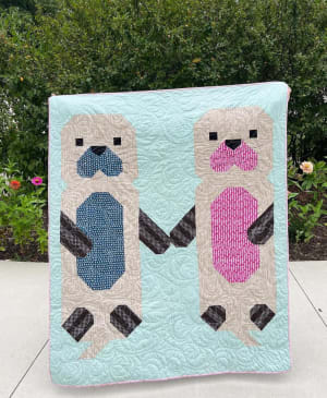 Woollypetals Don't Let Go Quilt with two appliqué figures in blue and pink