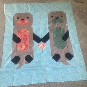 Woollypetals Don't Let Go Quilt with two figure blocks in red and green fabrics