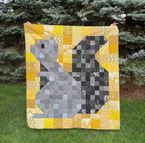 Woollypetals Squirrel quilt with yellow border and patchwork center