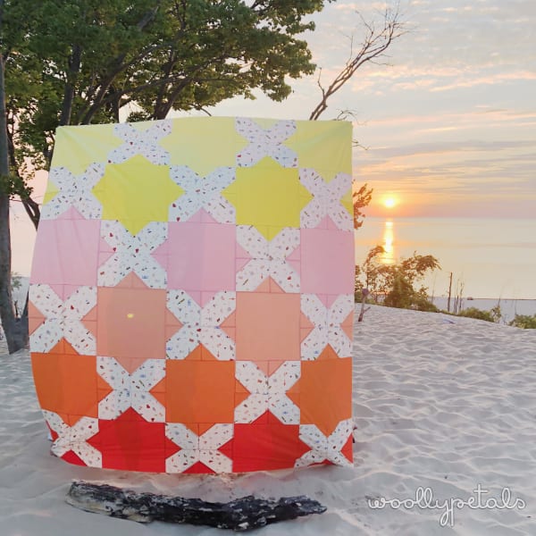Woollypetals Floored quilt with colorful star and diamond blocks in snow