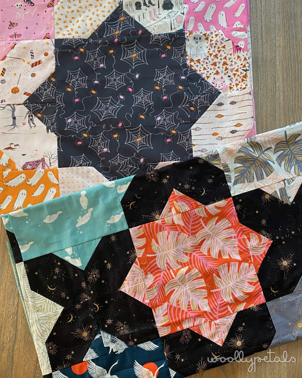 Woollypetals Floored quilt with star block in orange and black fabrics surrounded by coordinating prints
