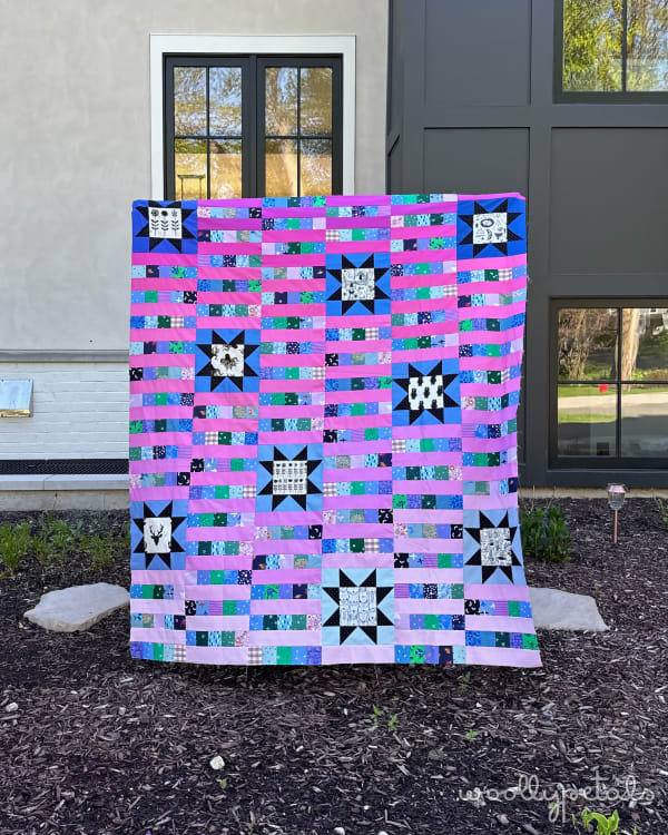 Woollypetals StarBeam quilt with pink, blue, and green star blocks