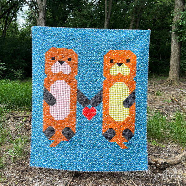 Woollypetals Don't Let Go quilt featuring two orange otters on blue background