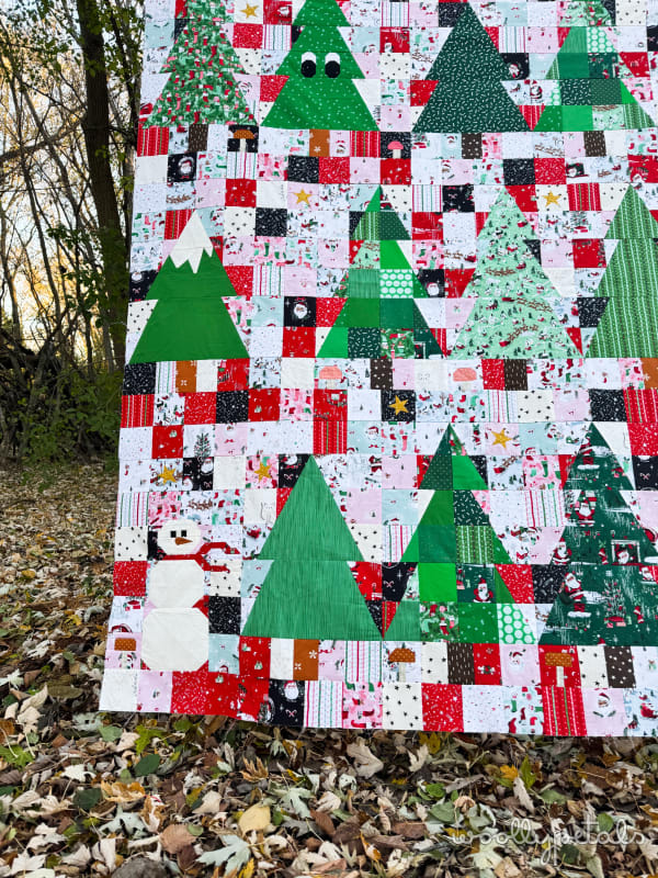 Woollypetals Enchanted Forest Quilt with green trees and colorful patchwork blocks