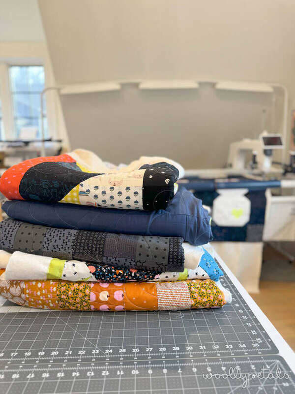 Stack of folded fabric strips with various patterns on a cutting mat
