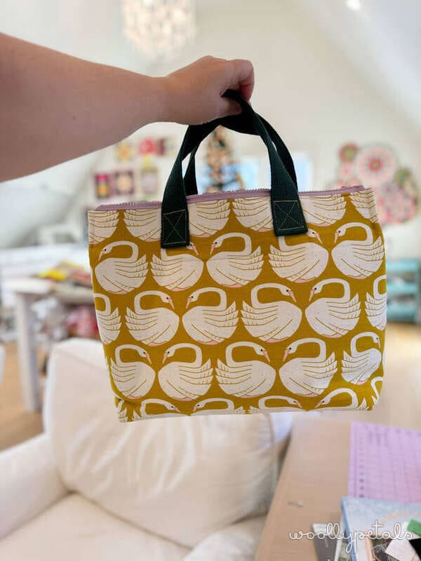 Gold and cream patterned fabric tote bag with black handles