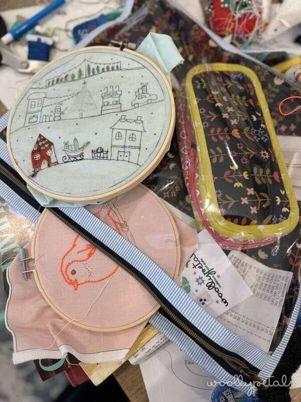 Embroidery hoops and project bags with various needlework and sewing supplies