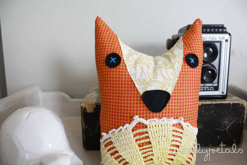 Orange fabric fox pincushion with embroidered details and pointed ears