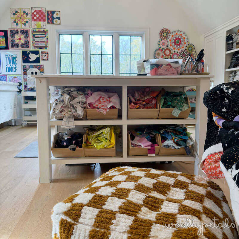 Sewing room storage with wooden shelving unit filled with fabric and supplies