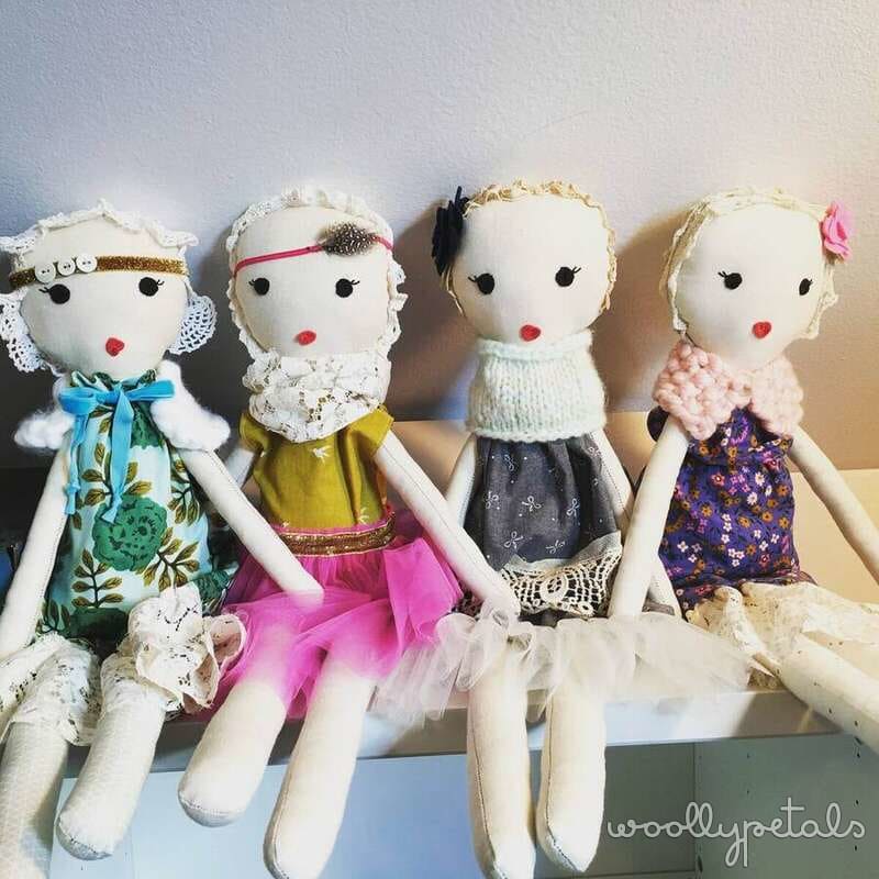 Four handmade fabric dolls with different outfits and accessories