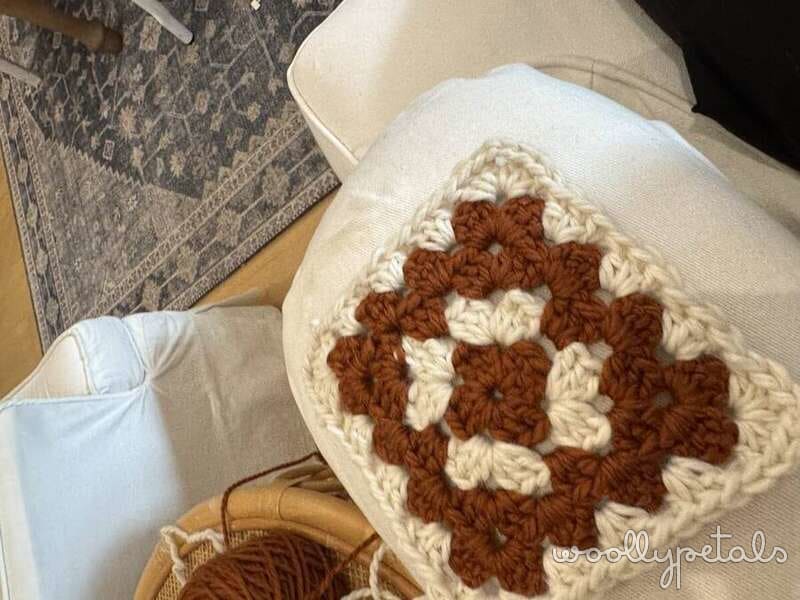 Granny square cardigan in progress with brown and cream crochet squares