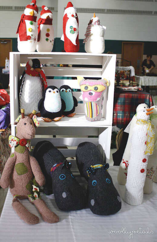 Handmade crocheted and knitted animals displayed on white shelving unit