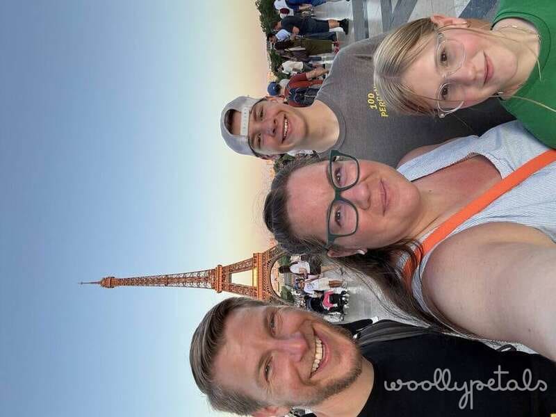 Family of four smiling in front of Eiffel Tower in Paris